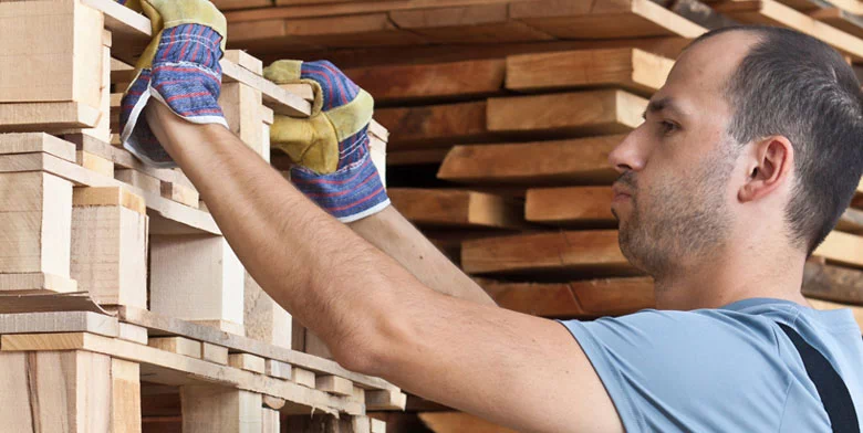robotnik układający deski drewniane